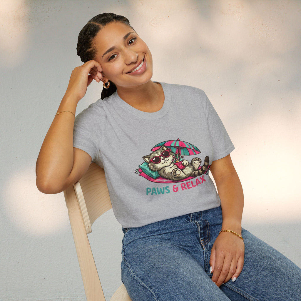 Person wearing a gray t-shirt with a cat graphic and 'Paws & Relax' text, sitting on a chair.